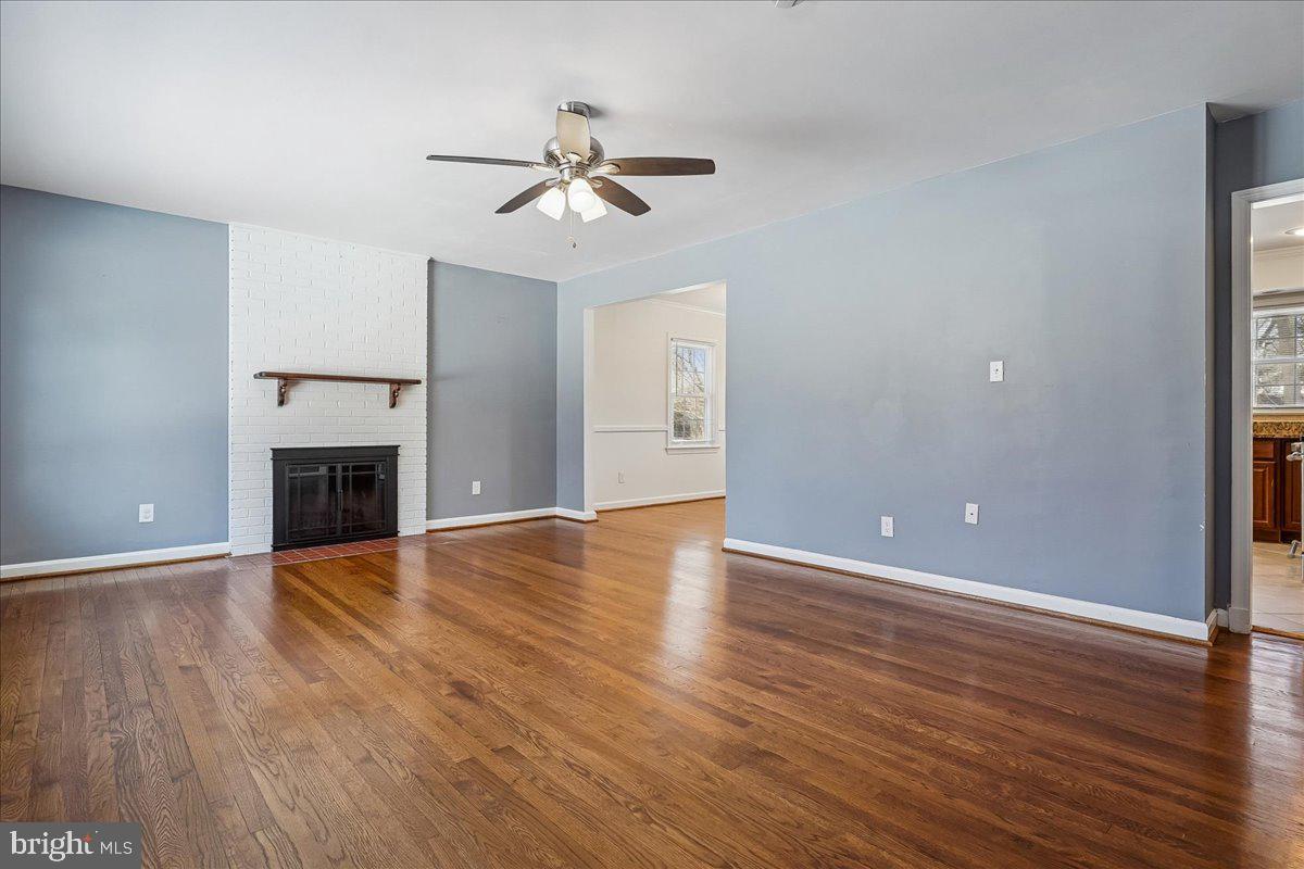 7039 Calamo Street Springfield, VA 22150 - Photo 7 of 70 a view of an empty room with wooden floor and a fireplace
