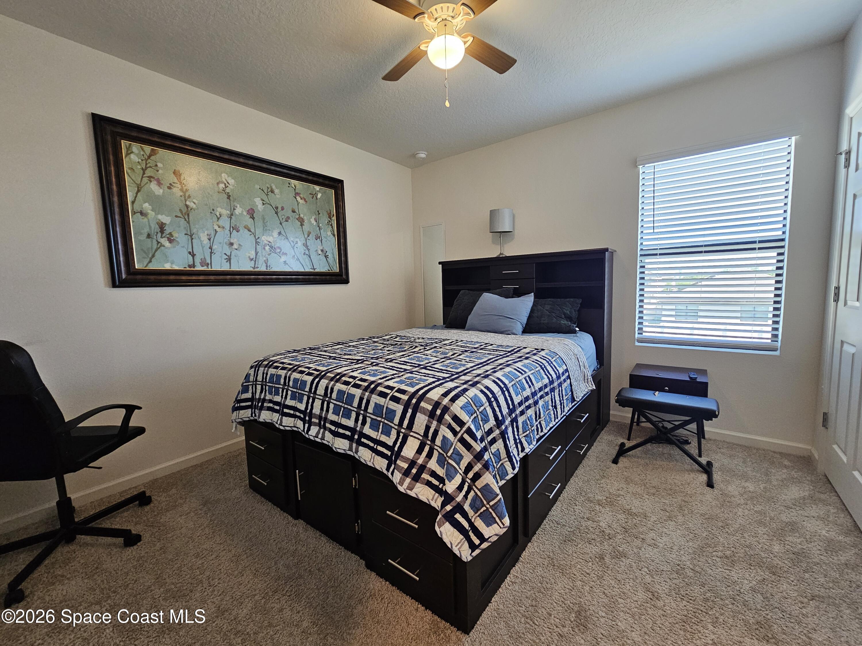 456 Snook Place Cocoa, FL 32927 - Photo 12 of 15 a bedroom with a bed a chair and a large window