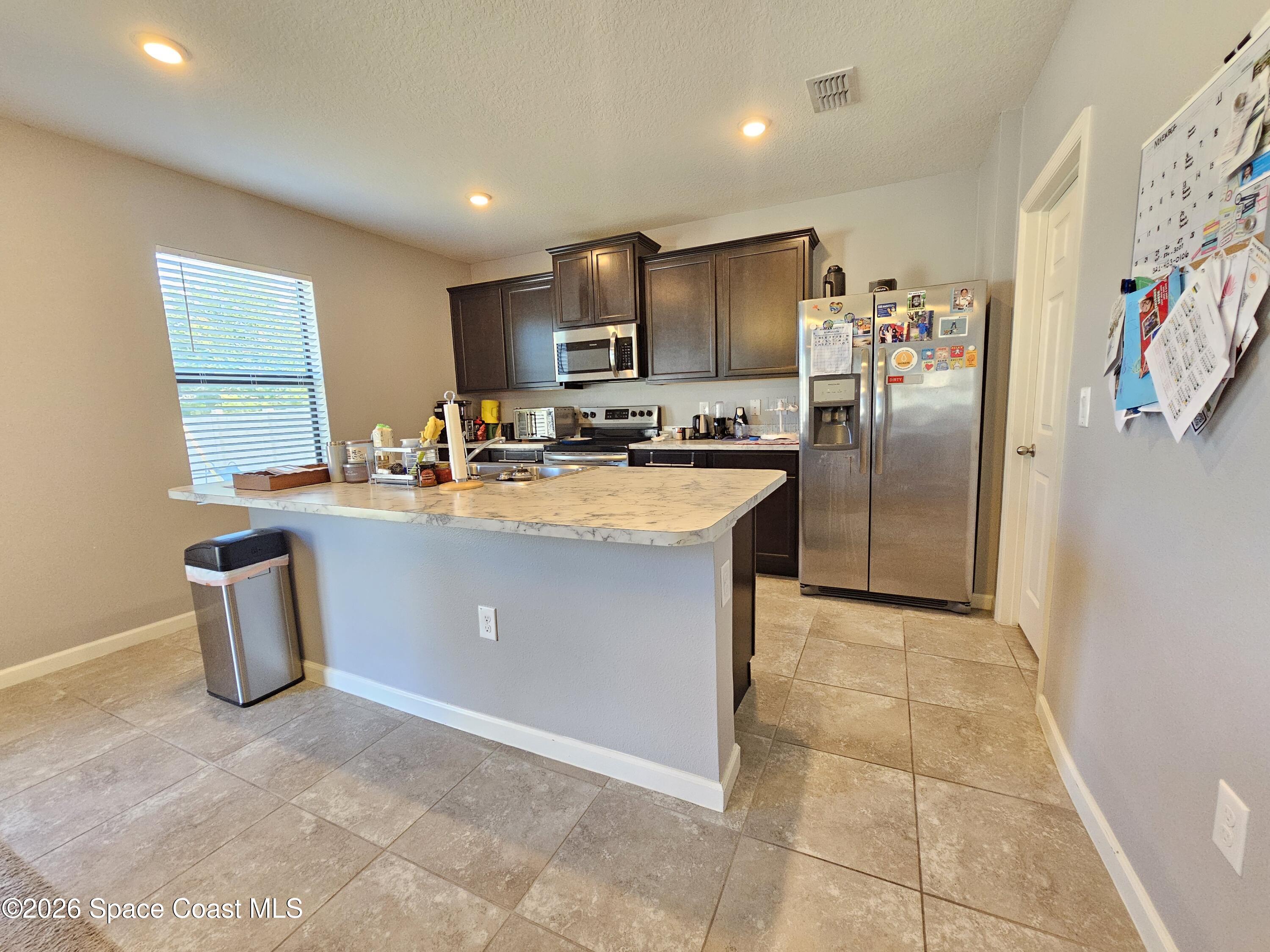 456 Snook Place Cocoa, FL 32927 - Photo 5 of 15 a kitchen with stainless steel appliances a refrigerator sink and microwave