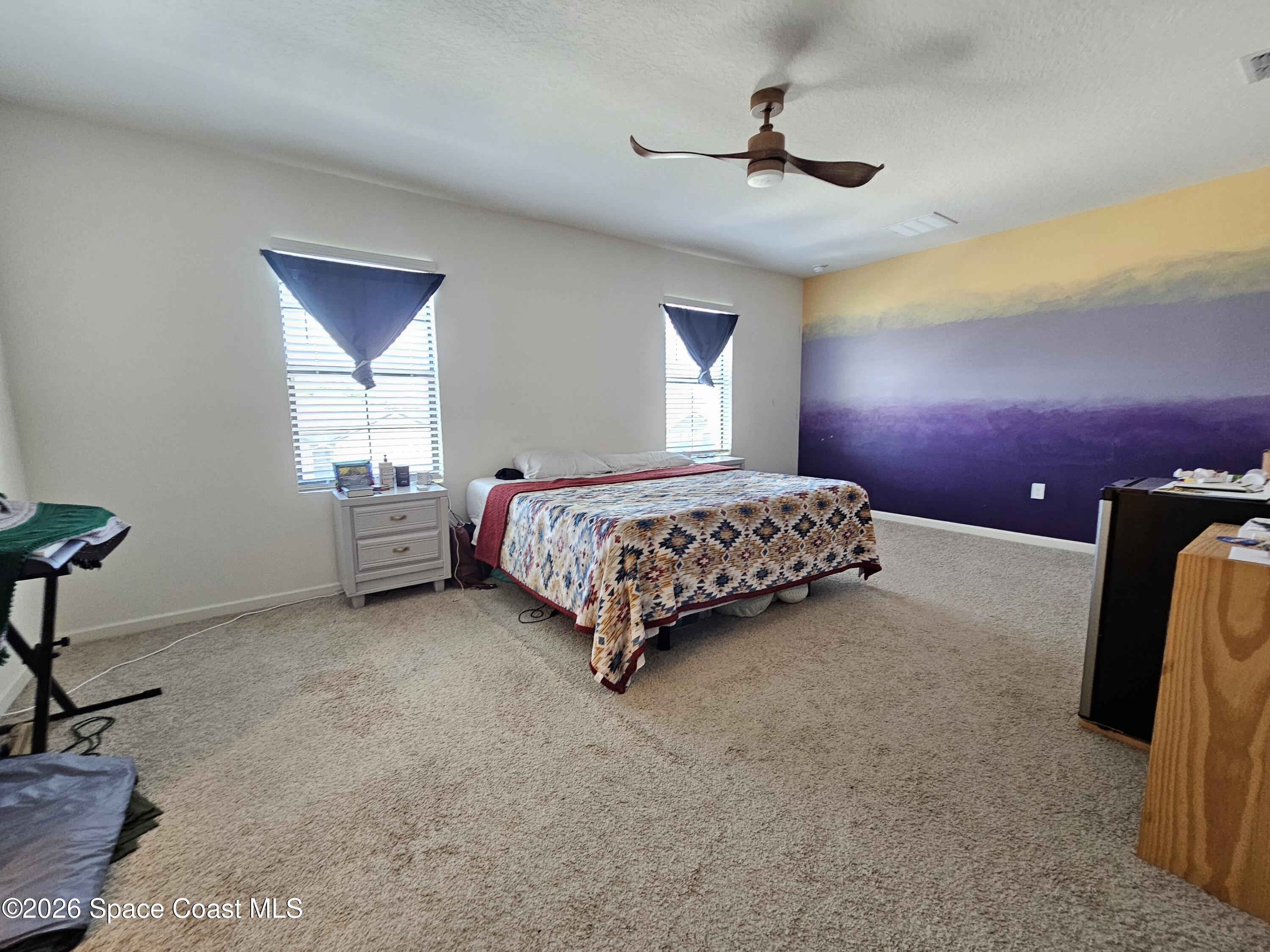 456 Snook Place Cocoa, FL 32927 - Photo 10 of 15 a spacious bedroom with a bed and a chandelier