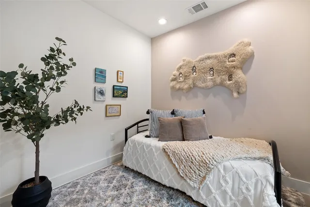 a bedroom with a large bed and a potted plant