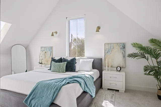 a bedroom with a bed and a potted plant