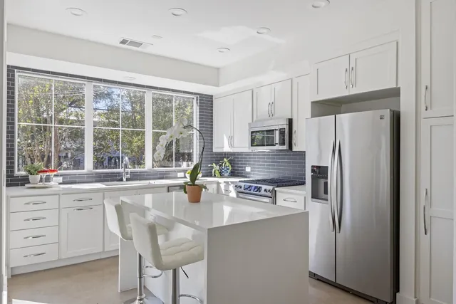 a kitchen with stainless steel appliances a refrigerator sink and cabinets