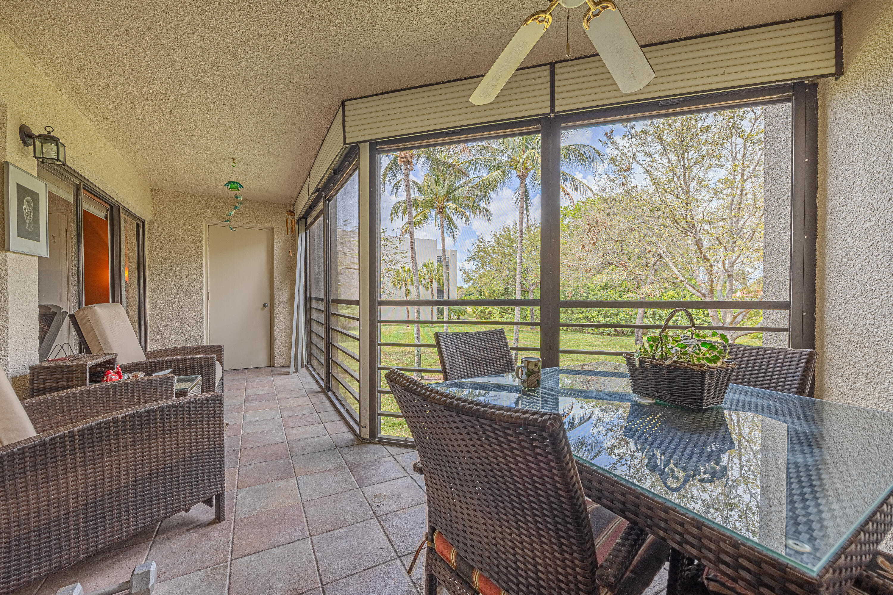 5750 Camino Del Sol, Unit 202 Boca Raton, FL 33433 - Photo 16 of 24 a living room with furniture and a floor to ceiling window