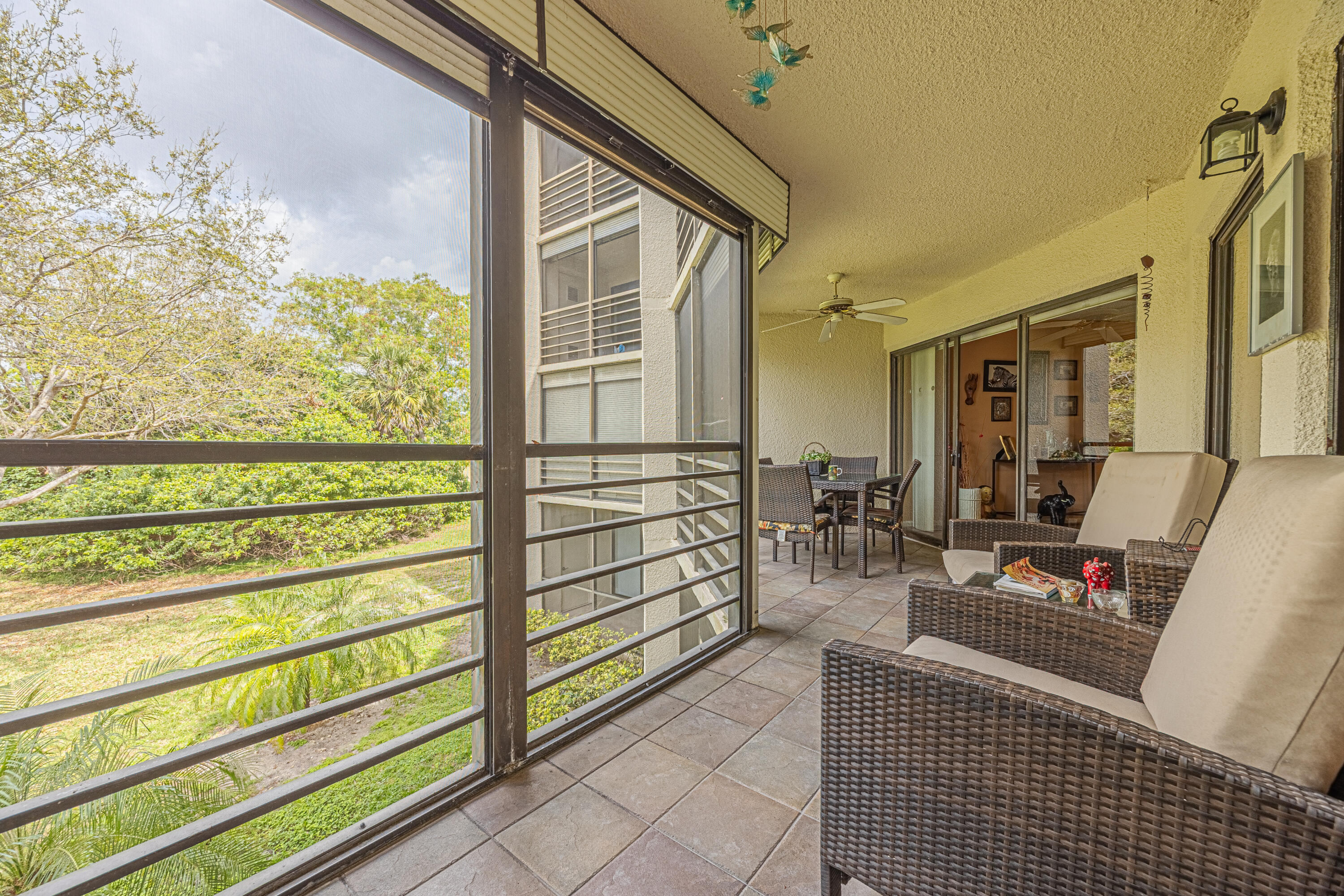 5750 Camino Del Sol, Unit 202 Boca Raton, FL 33433 - Photo 18 of 24 a view of a porch with chairs and front door