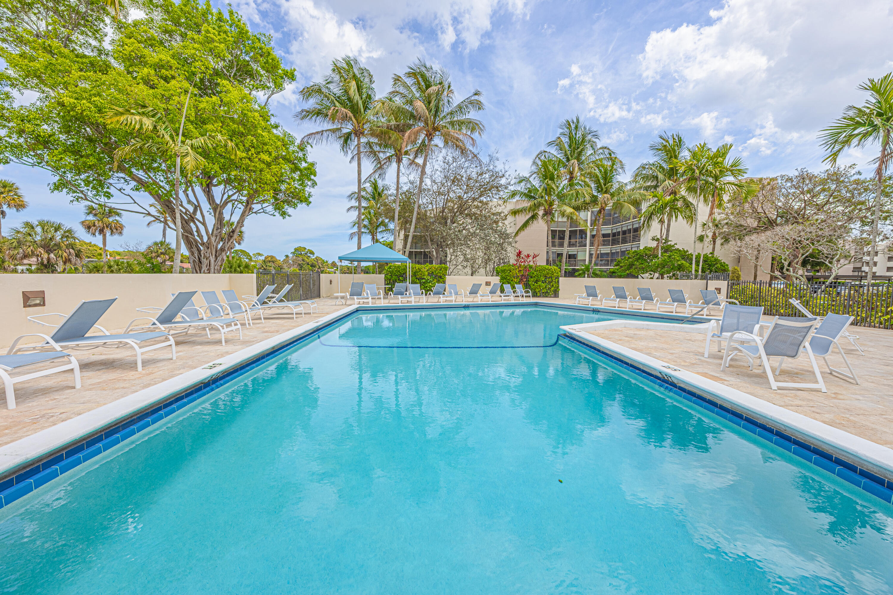 5750 Camino Del Sol, Unit 202 Boca Raton, FL 33433 - Photo 21 of 24 a view of a swimming pool with a lounge chair
