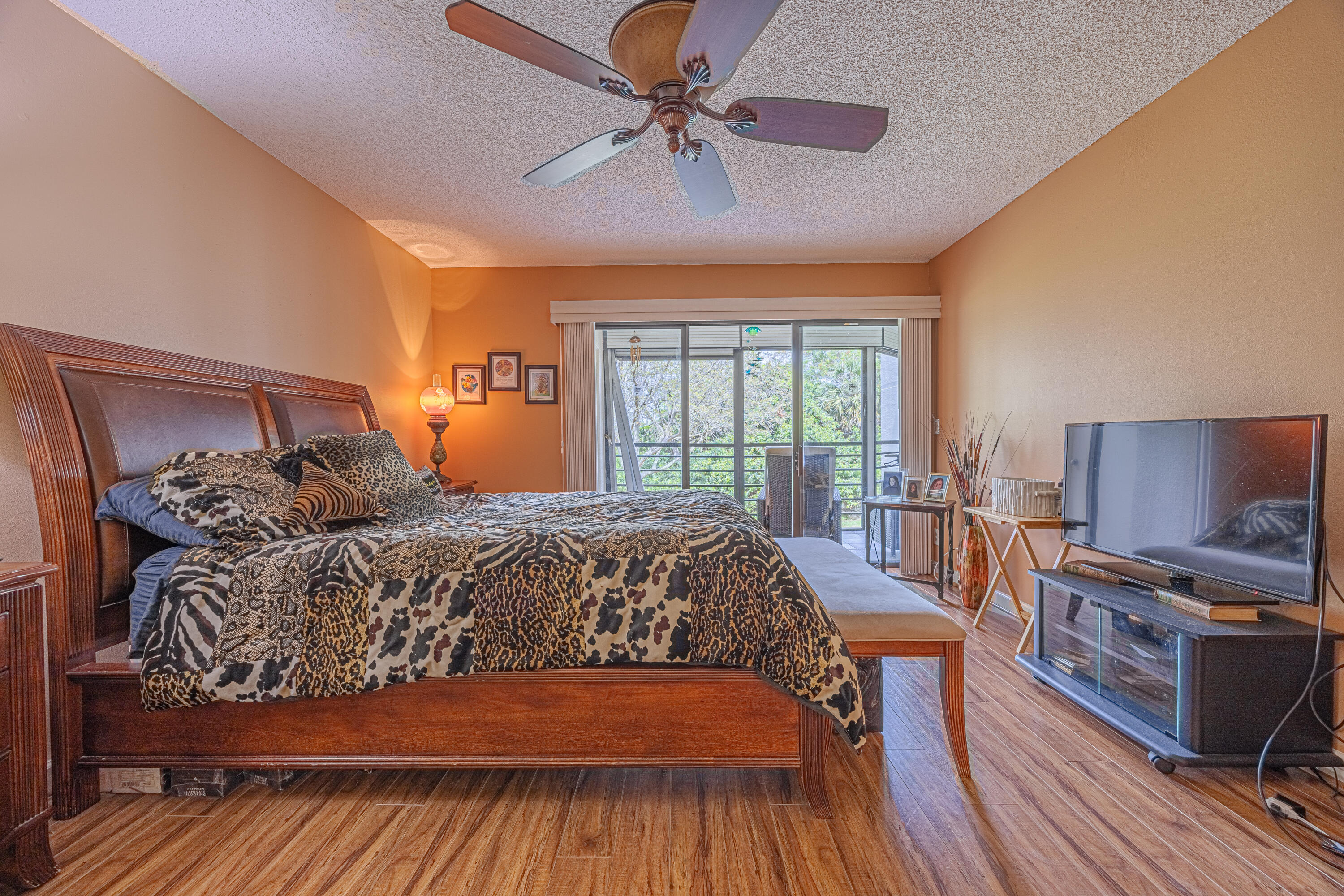 5750 Camino Del Sol, Unit 202 Boca Raton, FL 33433 - Photo 9 of 24 a bedroom with a bed and wooden floor