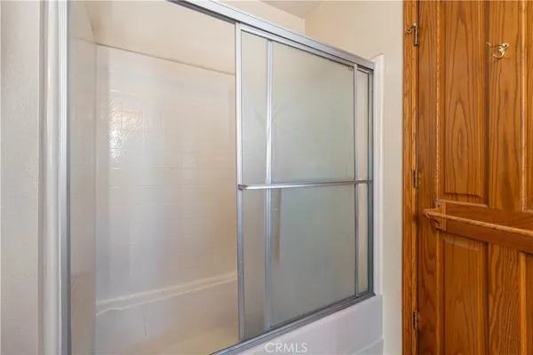 a view of an empty room with window and chandelier fan
