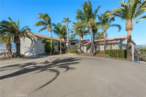 an empty room with large windows and fireplace