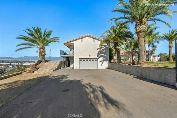 a bedroom with a bed a window and potted plant on the dresser