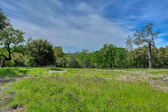 a view of an empty room with a window and a kitchen