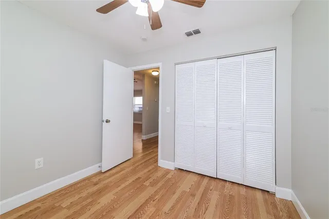 an empty room with a hardwood & ceiling fan
