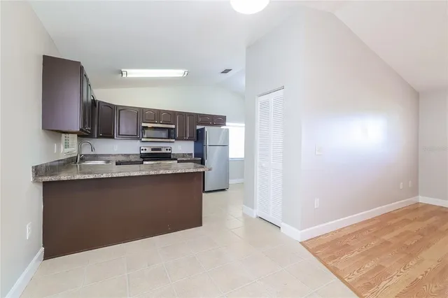 a kitchen with stainless steel appliances granite countertop a refrigerator and a sink