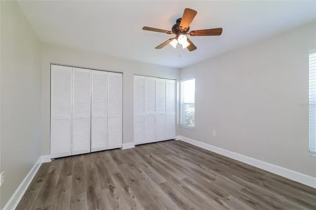 a view of a room with wooden floor and a ceiling fan