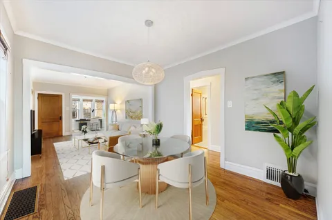 a dining room with furniture potted plants and wooden floor