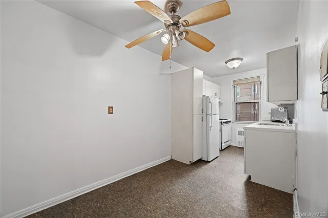 a kitchen with a refrigerator a stove a sink dishwasher and white cabinets with wooden floor