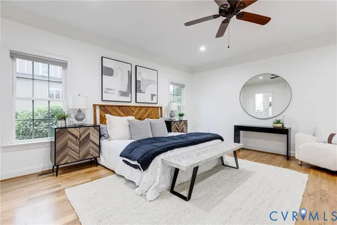 a bedroom with a bed a mirror and a large window