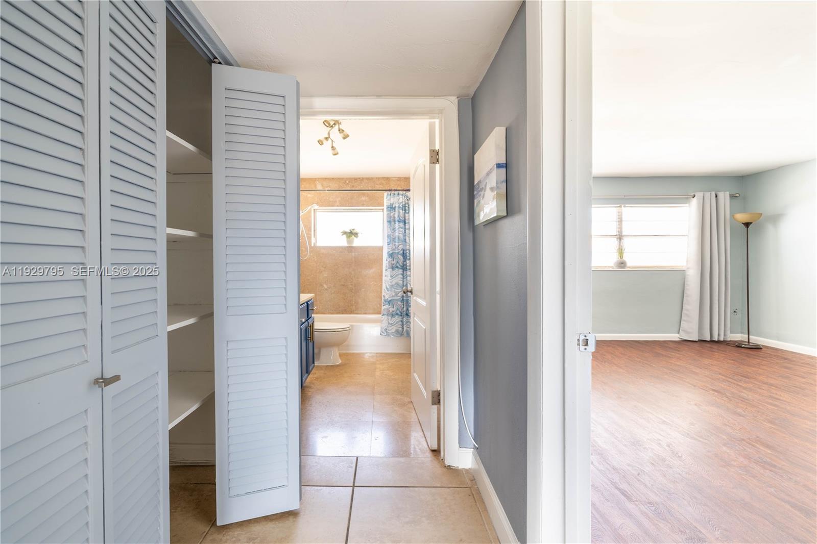 1855 Northeast 121st Street, Unit 32 North Miami, FL 33181 - Photo 11 of 22 a view of a hallway with wooden floor and a bathroom