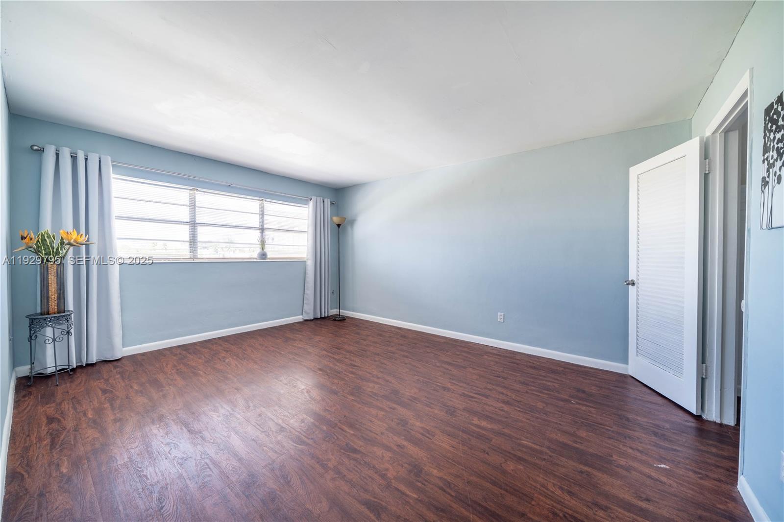 1855 Northeast 121st Street, Unit 32 North Miami, FL 33181 - Photo 14 of 22 an empty room with wooden floor and windows