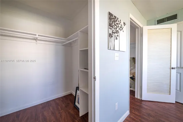 a view of walk in closet with wooden floor