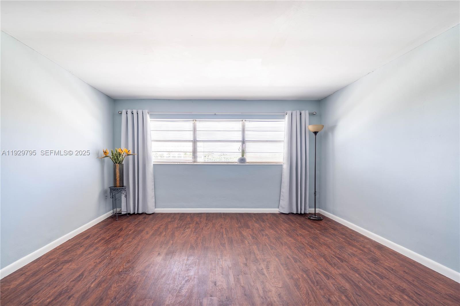 1855 Northeast 121st Street, Unit 32 North Miami, FL 33181 - Photo 18 of 22 an empty room with wooden floor and windows