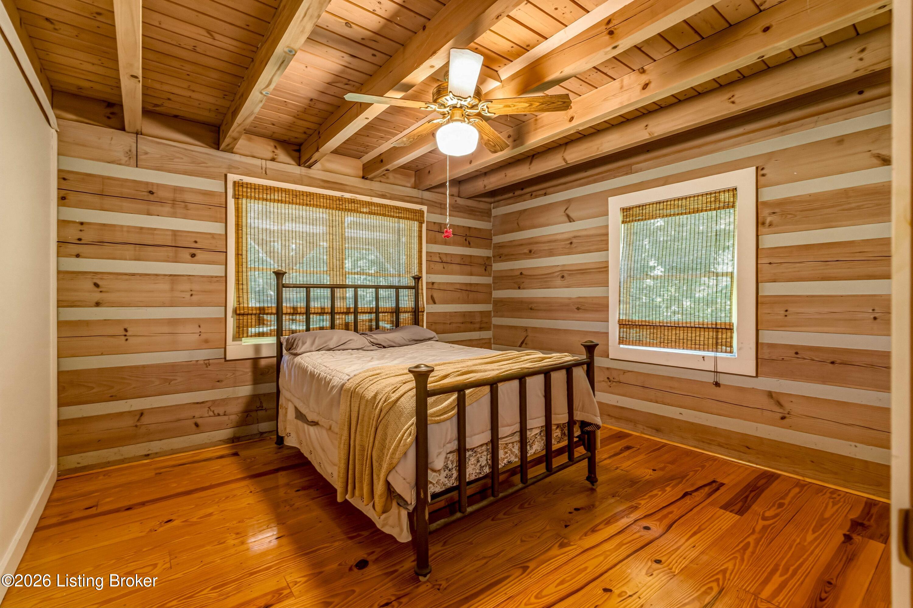 115 River Bend Road Glendale, KY 42740 - Photo 18 of 35 Log walls, hardwood floors, and a wrought iron bed that fits this cabin perfectly.
