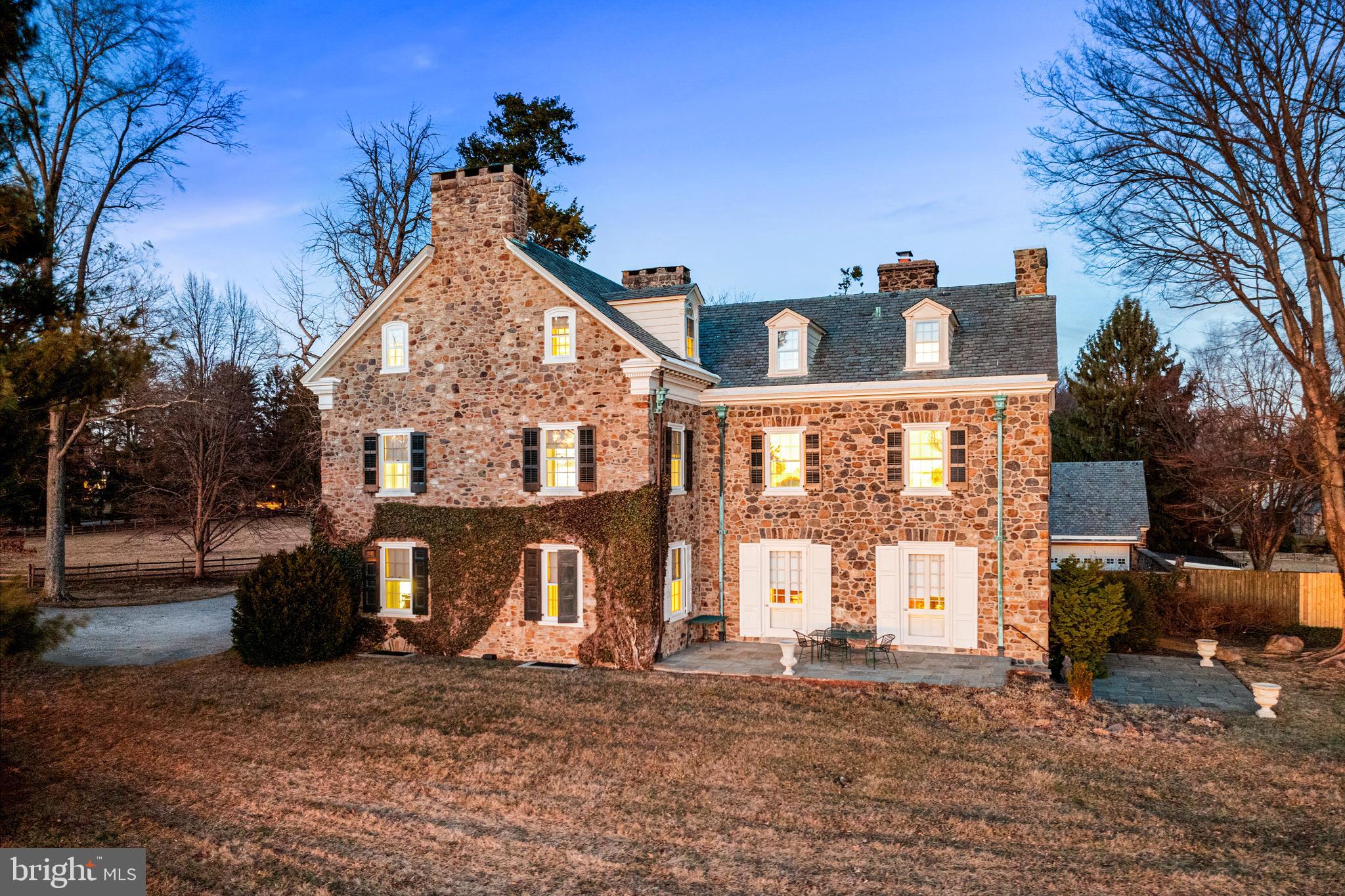705 Church Road Villanova, PA 19085 - Photo 4 of 54 a view of a white house with large windows and a yard