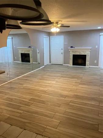 a view of empty room with wooden floor and fireplace