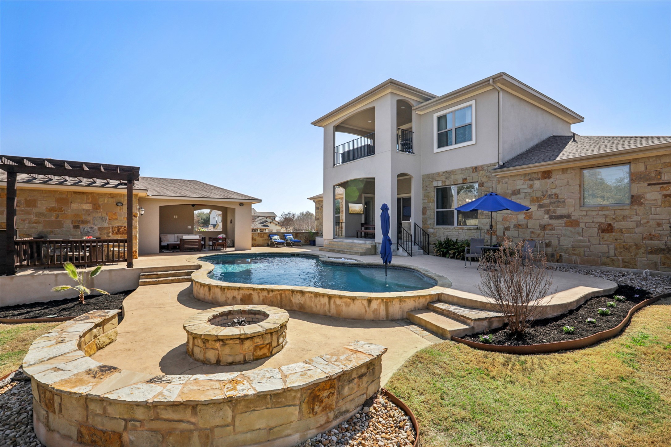Outdoor living oasis w/ fire pit, in-ground pool, pool house w/ bathroom, and covered patio w/ outdoor kitchen