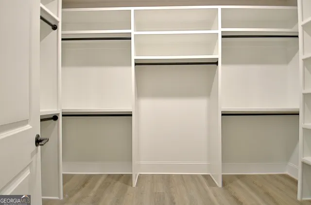 a view of walk in closet with empty racks