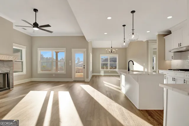 a large kitchen with kitchen island a large counter space a sink appliances and cabinets