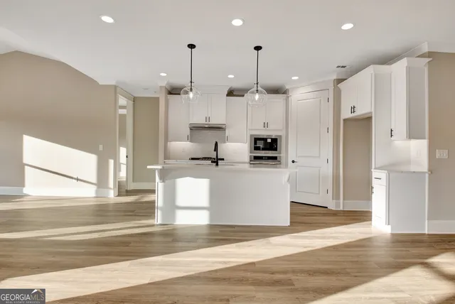 a view of kitchen with stainless steel appliances kitchen island a stove a refrigerator a sink and a cabinets