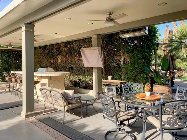 a view of a patio with table and chairs and potted plants