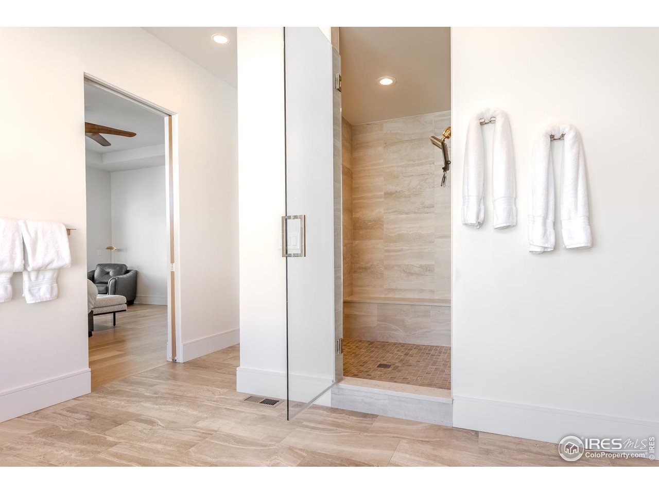 7572 Raphael Lane Littleton, CO 80125 - Photo 22 of 50 The rejuvenating private shower room features floor-to-ceiling tile, a built-in bench, two shower heads and a frameless glass entry.