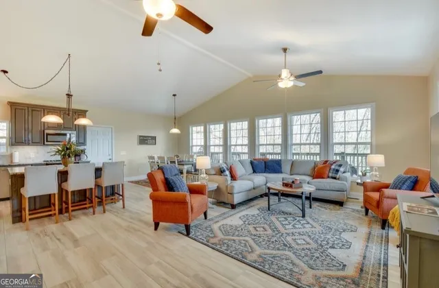 a living room with furniture kitchen view and a large window