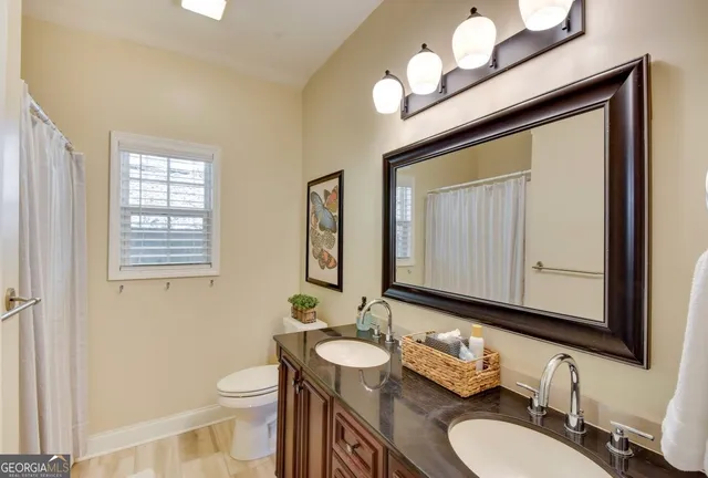 a bathroom with a granite countertop sink mirror and toilet