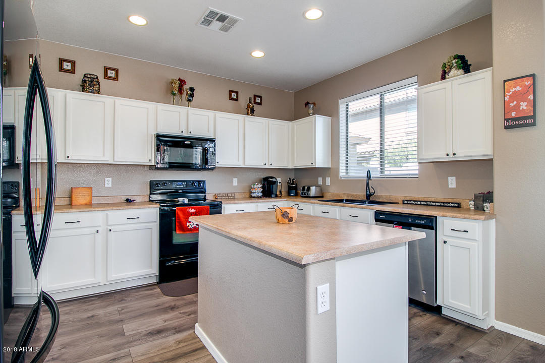 3954 East Morelos Street Gilbert, AZ 85295 - Photo 12 of 31 a kitchen with stainless steel appliances granite countertop a stove sink and cabinets
