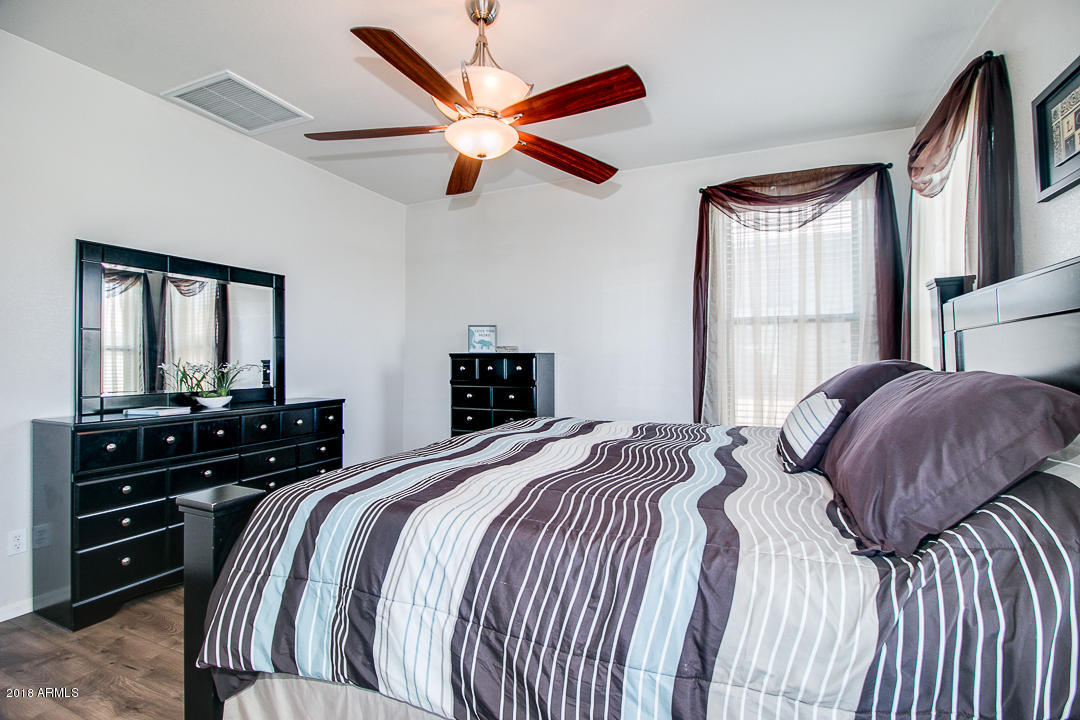 3954 East Morelos Street Gilbert, AZ 85295 - Photo 16 of 31 a bedroom with a bed and a chandelier