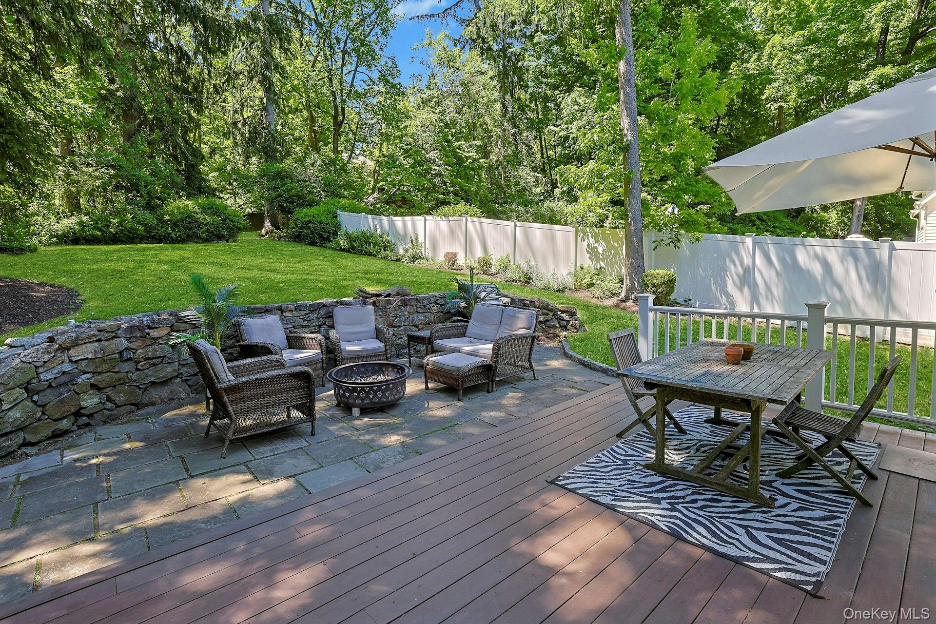 65 Douglas Road Chappaqua, NY 10514 - Photo 31 of 41 Enjoy outdoor living at its best with a welcoming patio area and fire pit, perfect for relaxing evenings, gathering with friends, and taking in the peaceful surroundings.