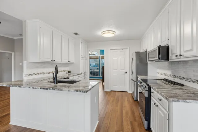 a kitchen with stainless steel appliances granite countertop a stove a sink and a refrigerator