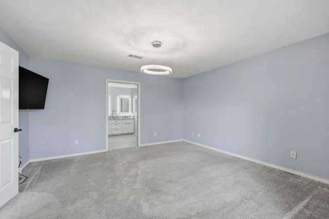 an empty room with windows and fireplace