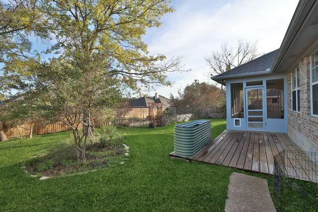 a view of backyard with deck and garden