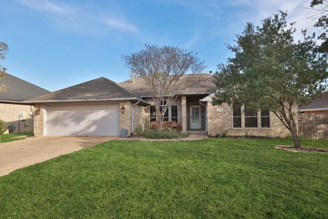 a front view of a house with a garden and trees