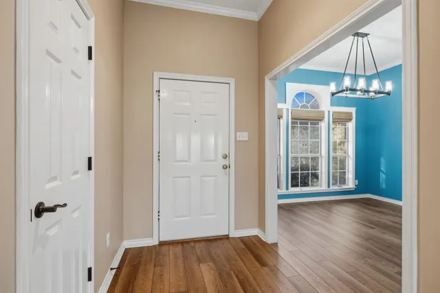 an empty room with wooden floor a ceiling fan and windows