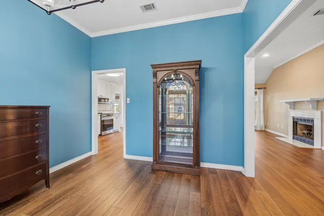 an empty room with wooden floor closet and windows