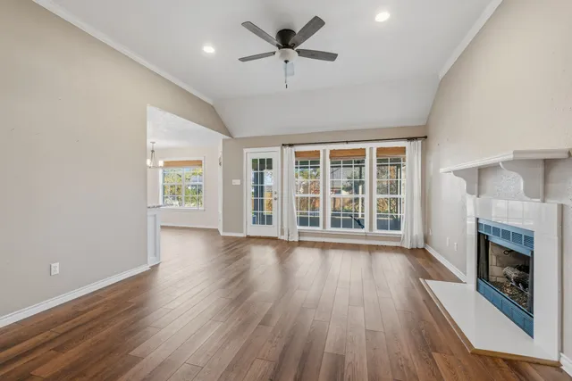 wooden floor fireplace and windows in an empty room