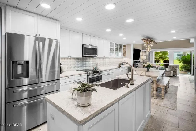 a living room with furniture a flat screen tv and a floor to ceiling window