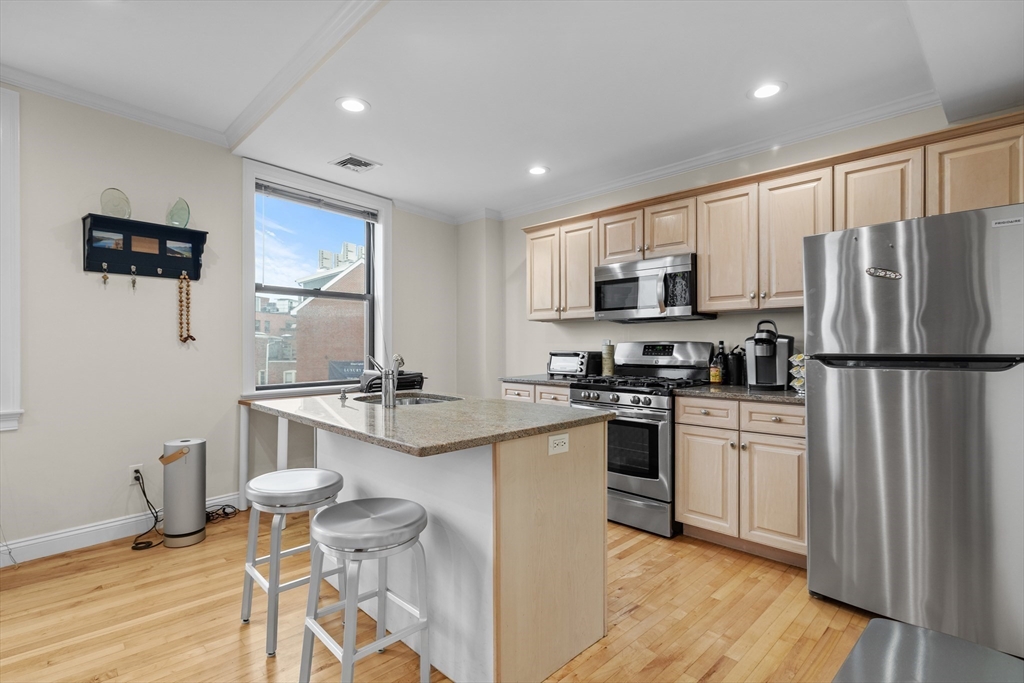 454 Hanover Street, Unit 5 Boston, MA 02113 - Photo 2 of 19 a kitchen with stainless steel appliances granite countertop a stove a sink and a refrigerator