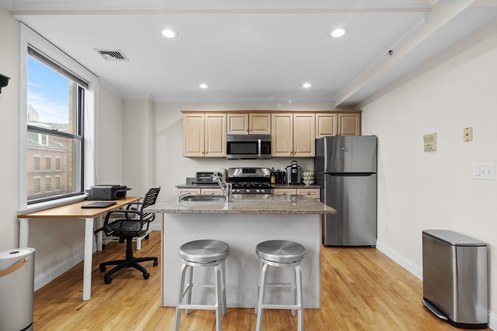 454 Hanover Street, Unit 5 Boston, MA 02113 - Photo 3 of 19 a kitchen with refrigerator a stove and chairs