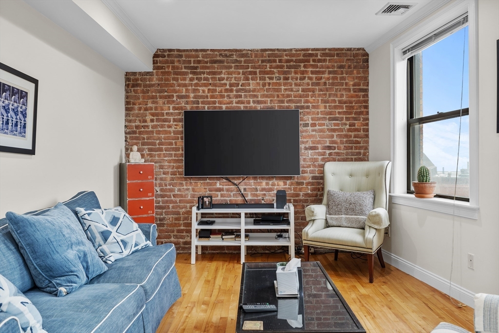 454 Hanover Street, Unit 5 Boston, MA 02113 - Photo 5 of 19 a living room with furniture a rug and a flat screen tv